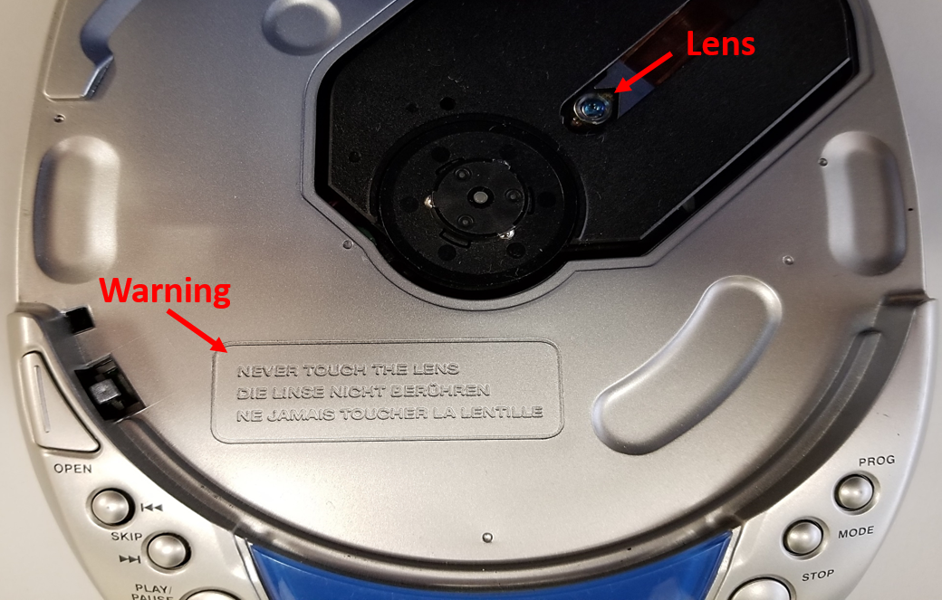 Portable CD player with the cover open. The lens is clearly visible and there is a warning to never touch the lens.