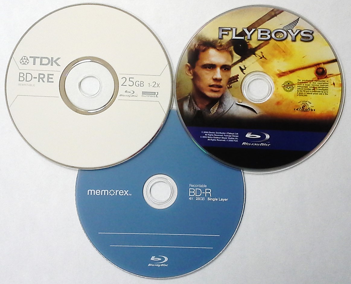 Three different types of Blu ray disk formats. Shown is a Blu-ray movie disc (Flyboys), a 4x BD-R or recordable Blu-ray from Memorex and a 25 GB rewritable Blu-ray or BD-RE from TDK.