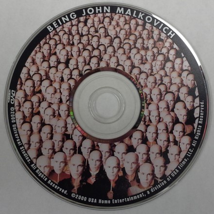 A DVD movie disc, Being John Malkovich. This is a single-sided dual-layer disc and therefore, a label is permitted on the top surface of the DVD.