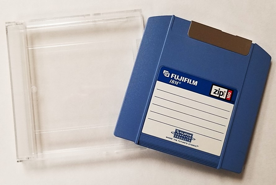 Zip disk 100 MB from Fujifilm and its plastic storage case, which provides protection from dust, debris, and physical damage.