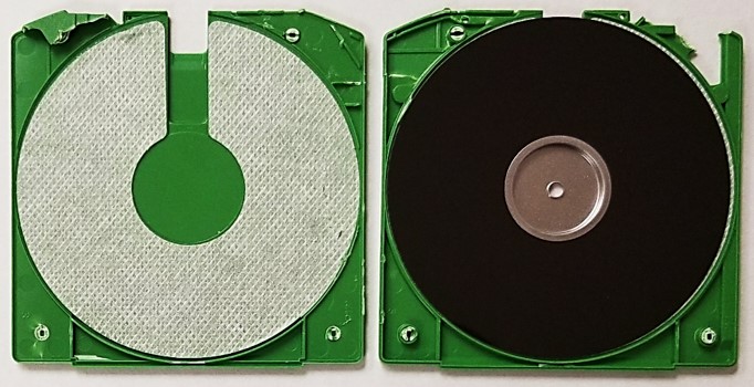 Iomega Zip disk jacket that has been opened to show the 3.5-inch floppy diskette inside as well as the woven liner that keeps the disk surfaces clean.